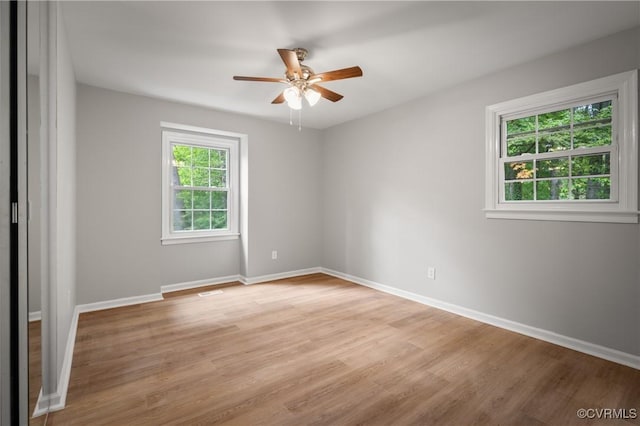 spare room with ceiling fan and light wood-type flooring