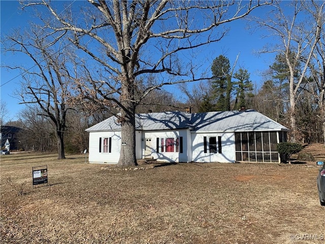 exterior space with a front lawn and a sunroom