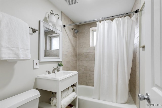 bathroom with plenty of natural light, shower / tub combo, and toilet