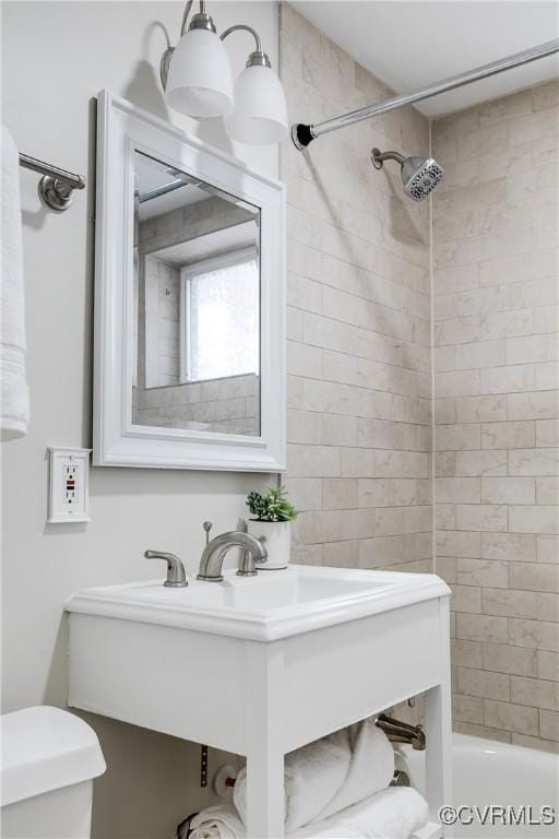 bathroom with tiled shower / bath and toilet