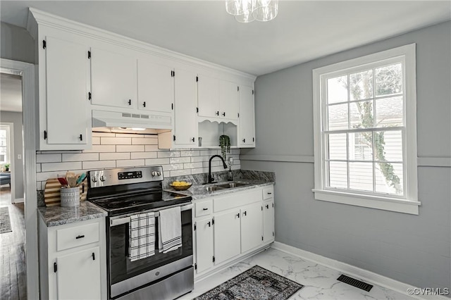 kitchen with sink, white cabinetry, stainless steel electric range oven, and dark stone counters