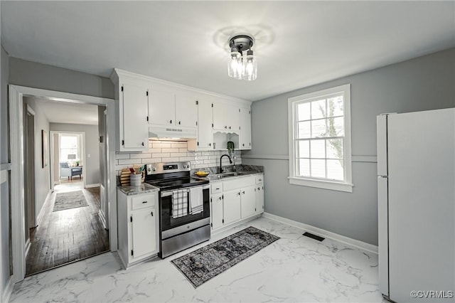 kitchen with decorative backsplash, stainless steel range with electric cooktop, white cabinets, light stone counters, and white refrigerator