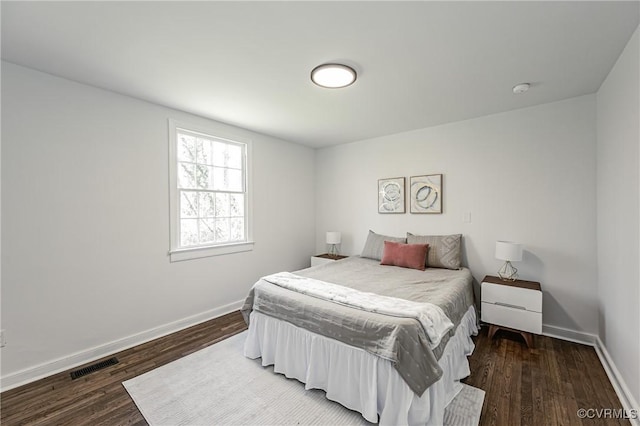 bedroom with dark hardwood / wood-style floors