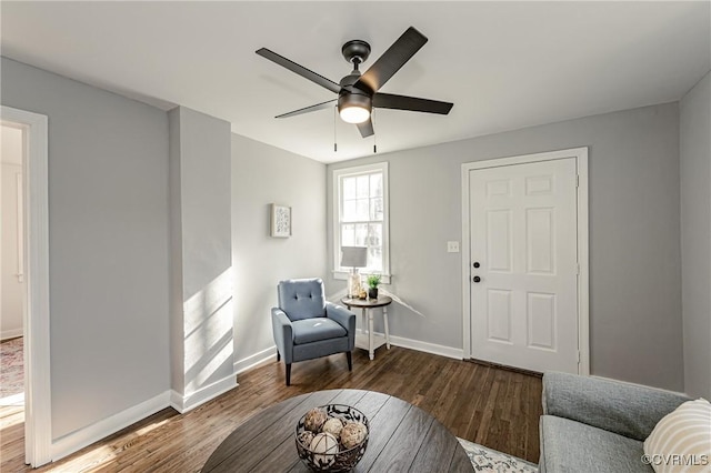 living area with ceiling fan and dark hardwood / wood-style flooring