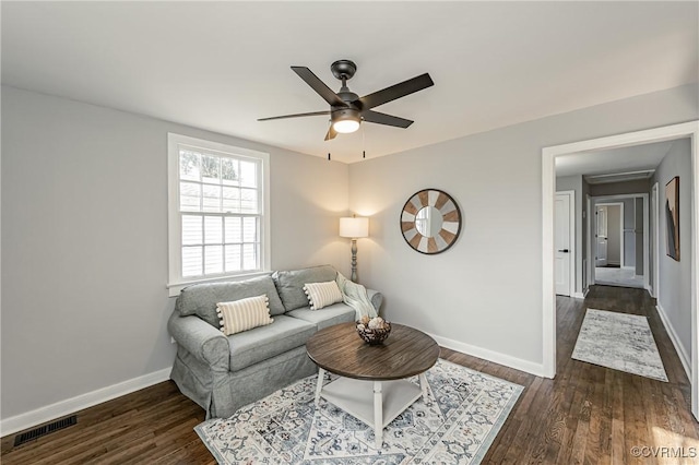 living room featuring ceiling fan and dark hardwood / wood-style flooring