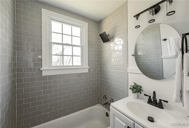 bathroom with tiled shower / bath combo and vanity