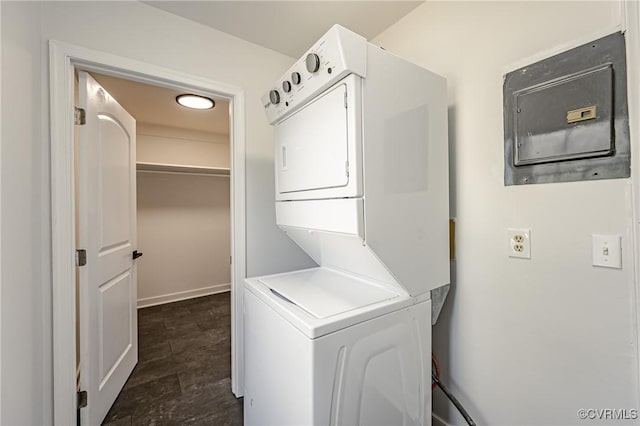 laundry room featuring electric panel and stacked washing maching and dryer