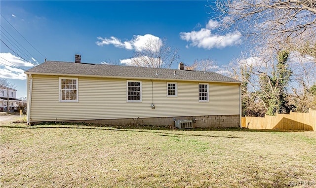 back of property featuring central AC unit and a lawn