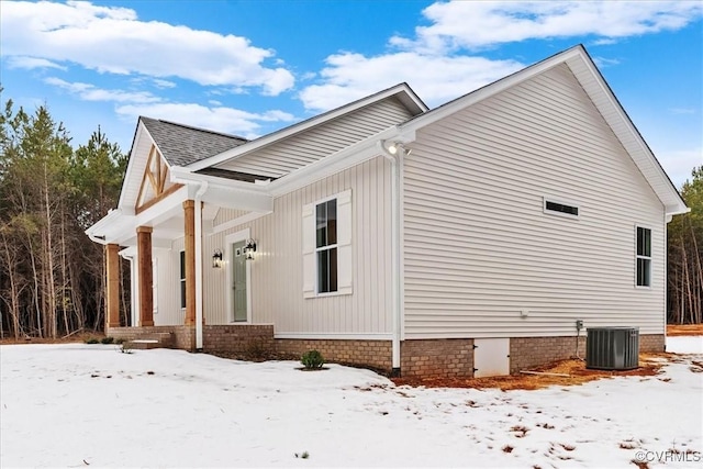 snow covered property with central AC