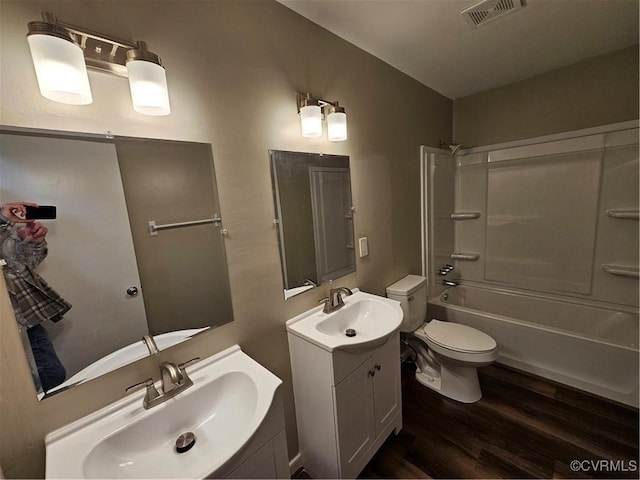 full bathroom with toilet, vanity, wood-type flooring, and washtub / shower combination