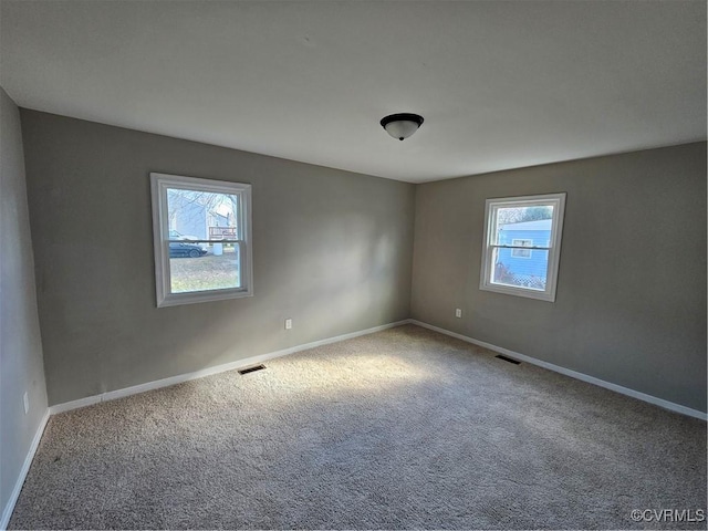 carpeted spare room featuring a healthy amount of sunlight