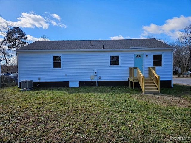 back of property with a lawn and central AC