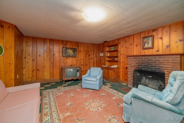 carpeted living room featuring a brick fireplace and wooden walls