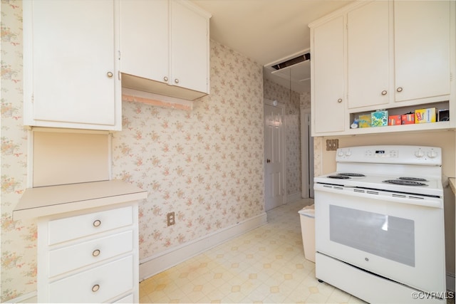 kitchen featuring white electric stove and white cabinetry