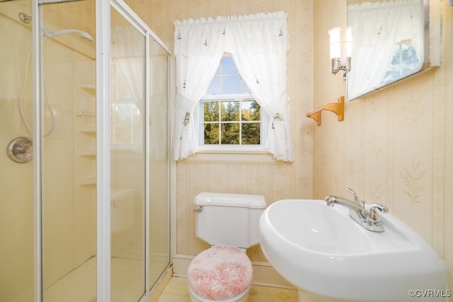 bathroom featuring walk in shower, sink, and toilet