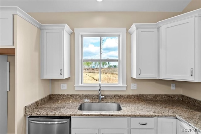 kitchen featuring a wealth of natural light, stainless steel dishwasher, white cabinets, and sink