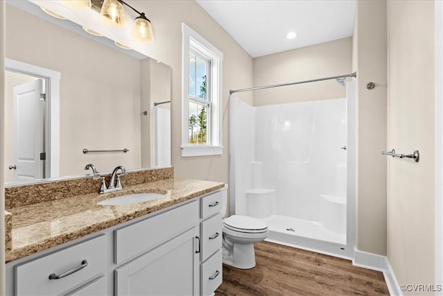 bathroom with toilet, walk in shower, wood-type flooring, and vanity