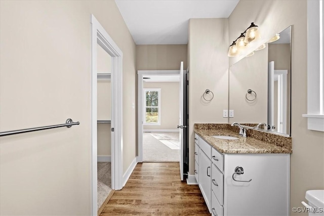 bathroom with toilet, vanity, and hardwood / wood-style flooring