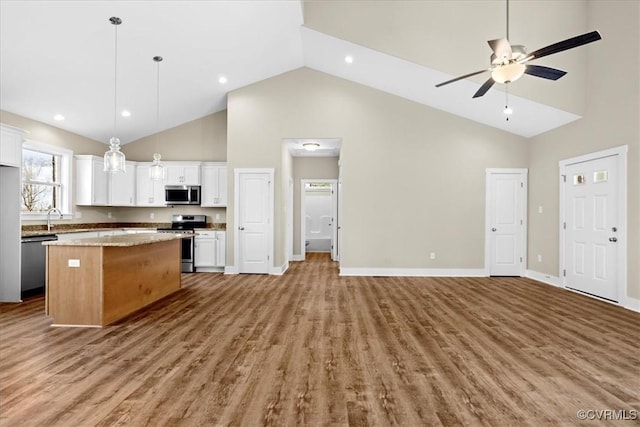 kitchen featuring stainless steel appliances, pendant lighting, white cabinets, and a center island