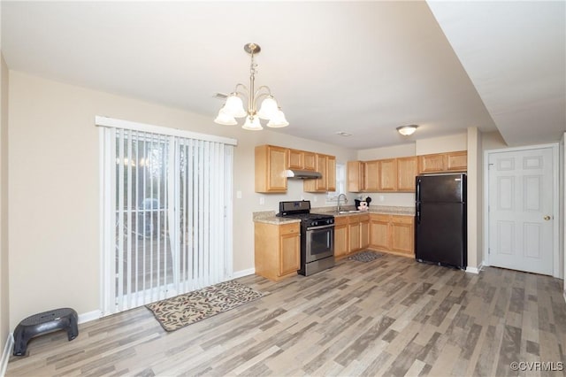 kitchen featuring black fridge, sink, light wood-type flooring, stainless steel gas range, and light brown cabinetry