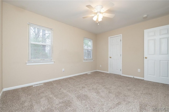 carpeted spare room with ceiling fan