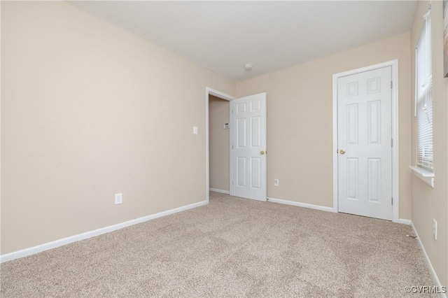 unfurnished bedroom featuring light carpet, a closet, and multiple windows