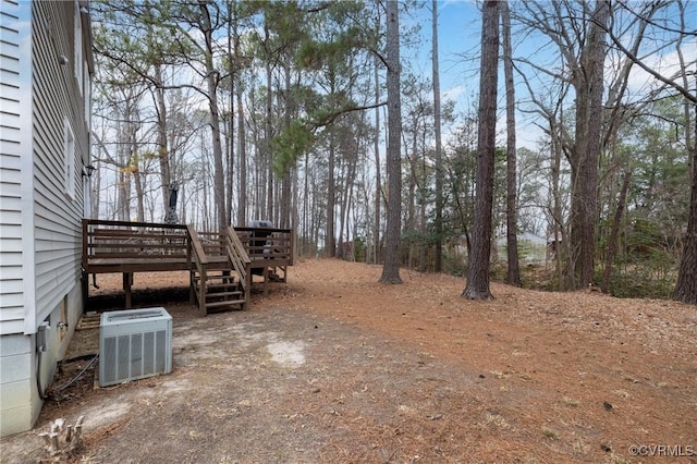 view of yard with a deck and central air condition unit