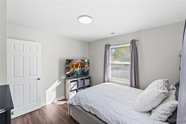 bedroom with dark hardwood / wood-style floors