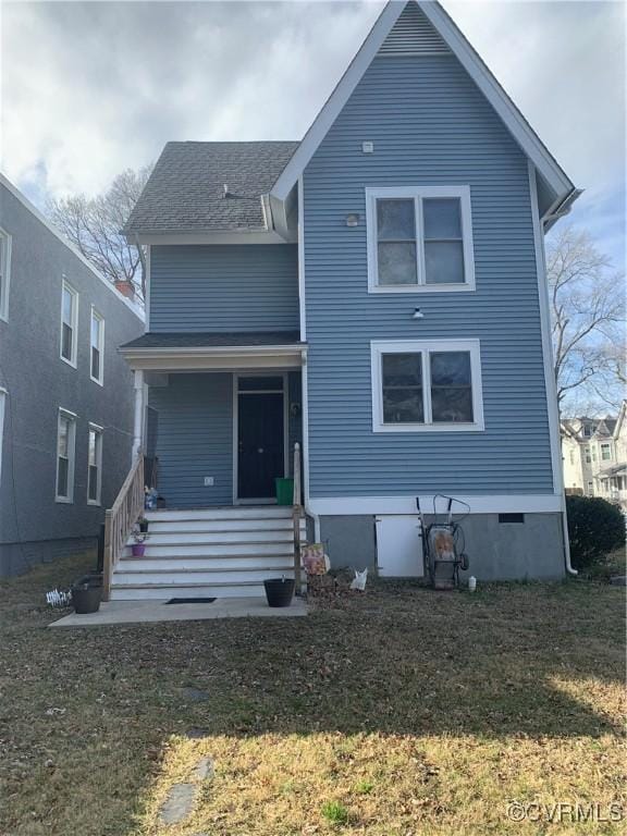 back of house featuring crawl space, covered porch, and a lawn