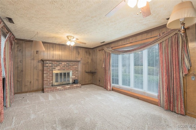 unfurnished living room featuring light carpet, a brick fireplace, a textured ceiling, and ceiling fan