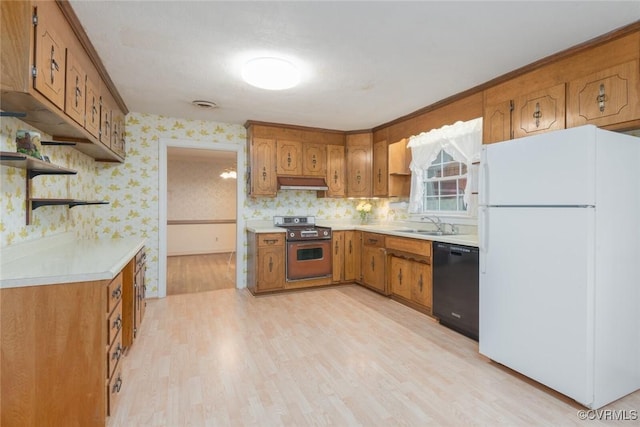 kitchen featuring sink, range, light wood-type flooring, white refrigerator, and black dishwasher