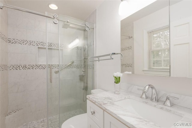 bathroom featuring vanity, toilet, and an enclosed shower