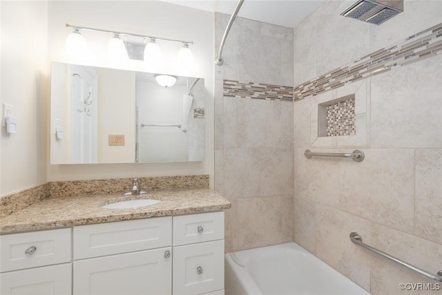 bathroom featuring tiled shower / bath and vanity