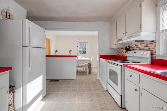 kitchen with white appliances, white cabinets, and tasteful backsplash