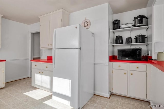 kitchen featuring white fridge and white cabinets