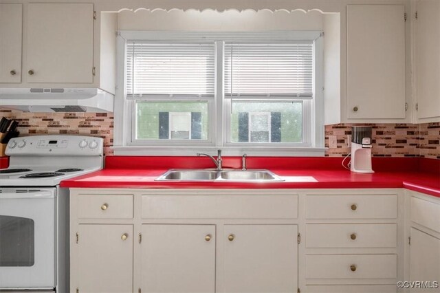 kitchen with electric stove, a wealth of natural light, sink, and white cabinets