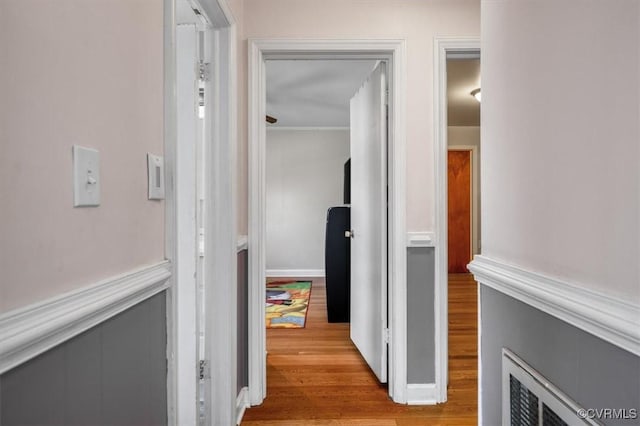 hallway with light hardwood / wood-style floors