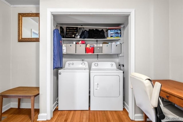 clothes washing area with light hardwood / wood-style floors, ornamental molding, and independent washer and dryer