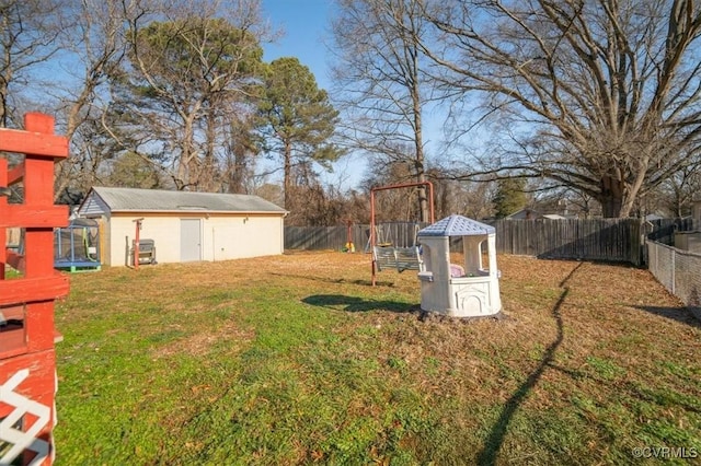 view of yard featuring a trampoline and a storage unit