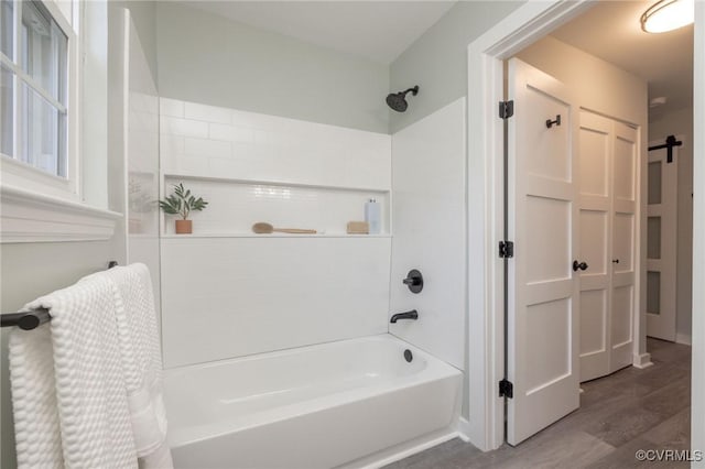 bathroom with wood-type flooring and bathing tub / shower combination