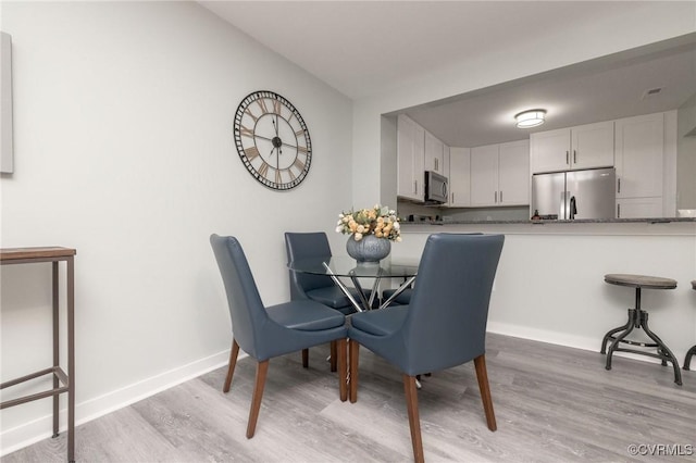 dining space with light hardwood / wood-style flooring