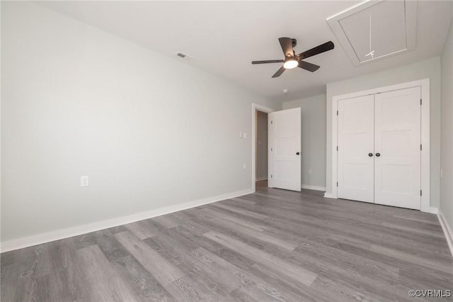 unfurnished bedroom featuring ceiling fan, hardwood / wood-style flooring, and a closet