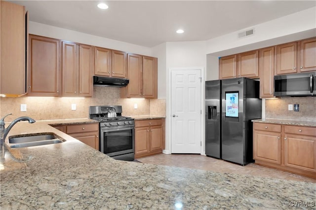 kitchen featuring light tile patterned floors, backsplash, sink, and stainless steel appliances