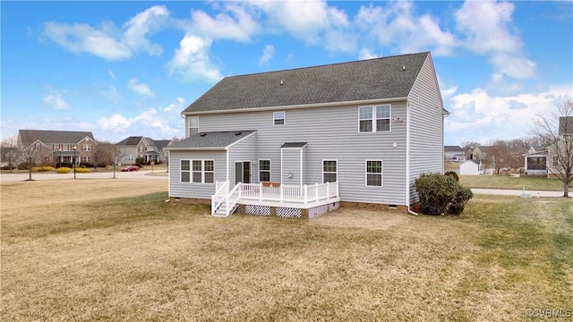 rear view of house featuring a wooden deck and a lawn