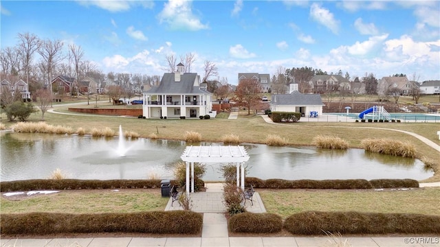 view of home's community featuring a water view, a pergola, and a yard