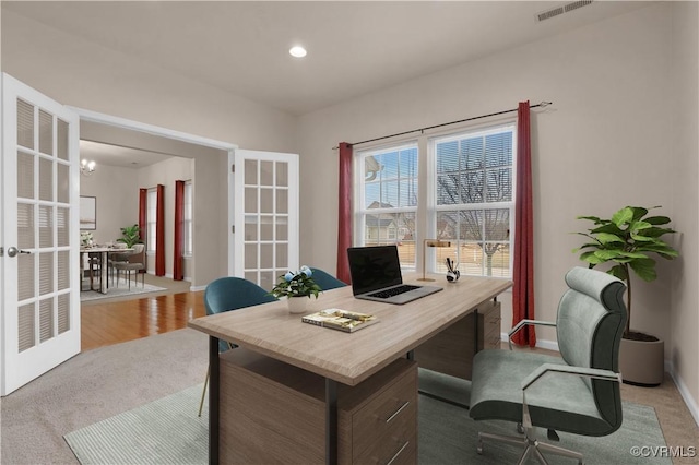 carpeted home office with french doors