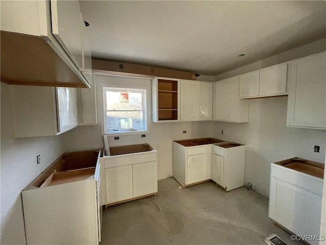 kitchen with white cabinets and washer / dryer