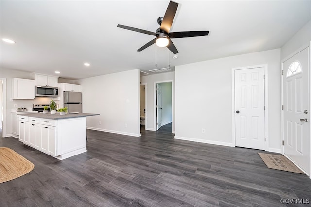 kitchen featuring ceiling fan, white cabinetry, dark hardwood / wood-style floors, and stainless steel appliances