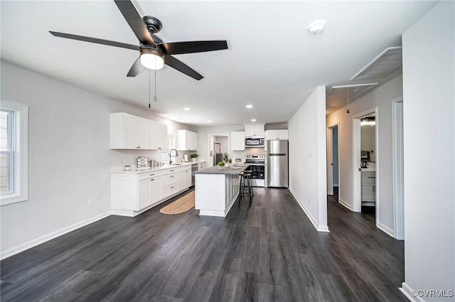 kitchen featuring a center island, a breakfast bar, sink, stainless steel appliances, and white cabinets