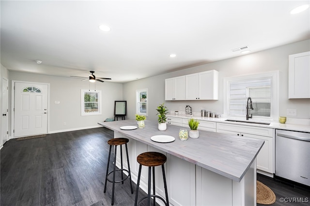 kitchen with stainless steel dishwasher, white cabinets, and sink